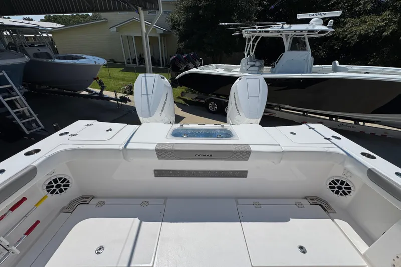 Slide: The Image of 2025 Caymas 34 CT boat with dual Mercury engines in a marina setting. - 44
