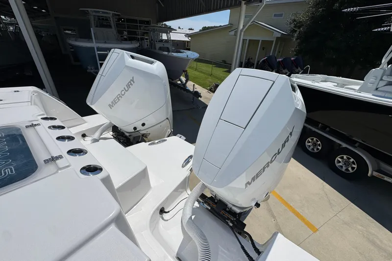 Slide: The Image of 2025 Caymas 34 CT boat with dual Mercury outboard engines in a marina setting. - 46