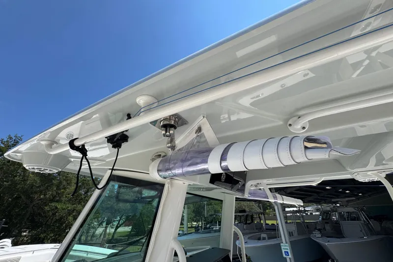 Slide: The Image of 2025 Caymas 34 CT boat with rod holder and canopy, under clear blue sky. - 49