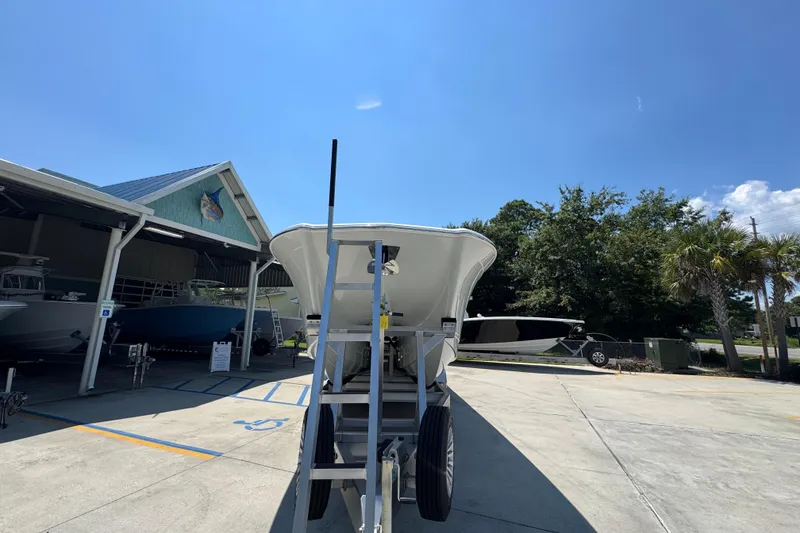 Slide: The Image of 2025 Caymas 34 CT boat on trailer under clear blue sky at dealership. - 7