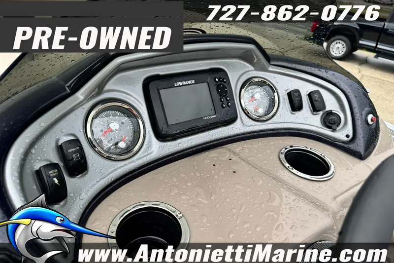 Slide: The Image of Pre-owned 2022 Sun Tracker 22 Sport Fish DLX dashboard with Lowrance display, raindrops visible. - 22