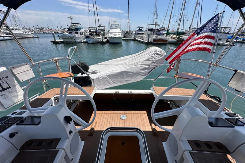 Slide: The Image of Cockpit view of 2018 Elan 45 Impressions yacht in marina, featuring dual steering wheels. - 25
