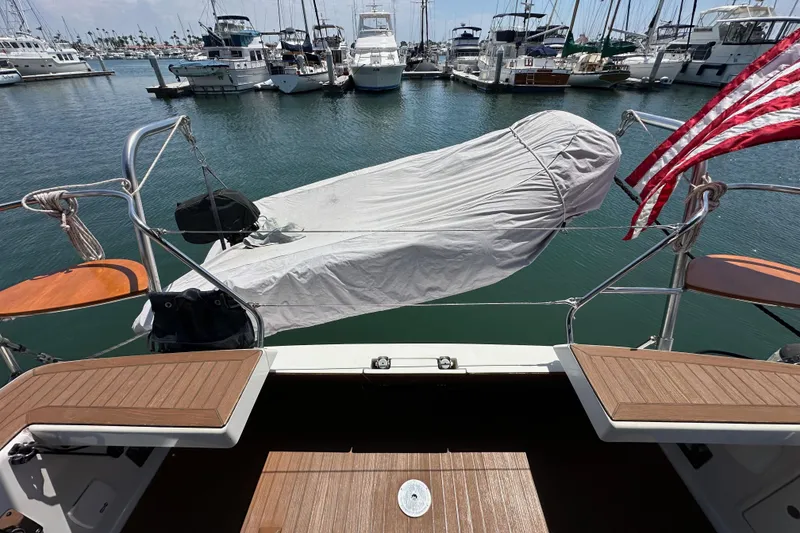 Slide: The Image of Elan 45 Impressions 2018 yacht stern view at marina with covered equipment. - 26