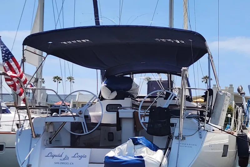 Slide: The Image of 2018 Elan 45 Impressions yacht docked, featuring dual steering wheels and a navy canopy. - 27