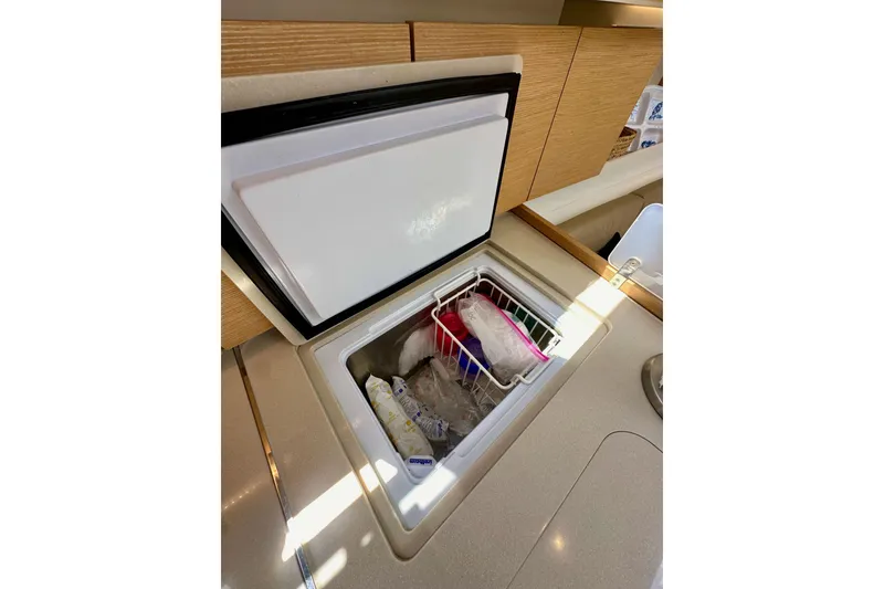 Slide: The Image of 2018 Elan 45 Impressions yacht interior with open freezer in the kitchen area. - 46