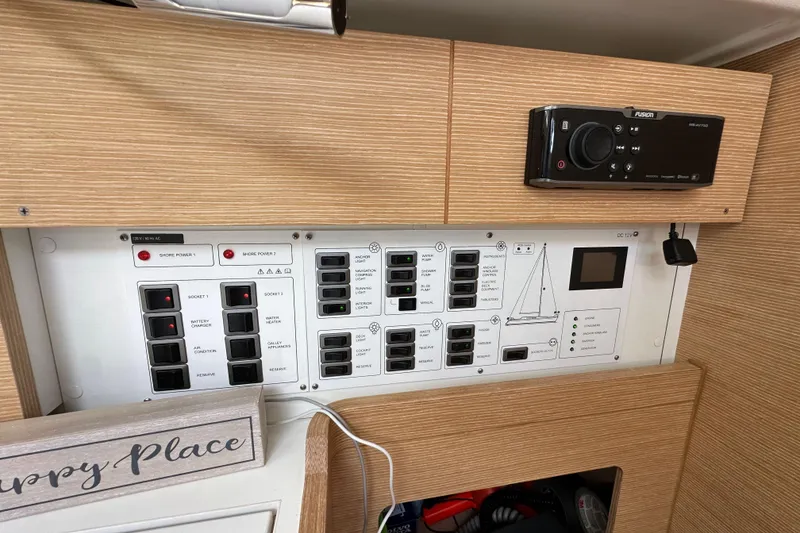 Slide: The Image of Control panel of a 2018 Elan 45 Impressions yacht with various switches and a stereo system. - 60