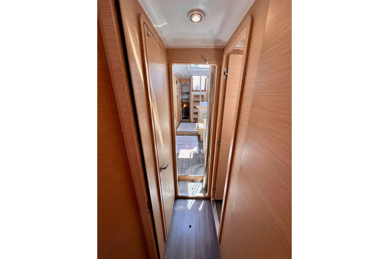 Slide: The Image of Narrow hallway inside 2018 Elan 45 Impressions yacht, featuring wooden doors and flooring. - 74