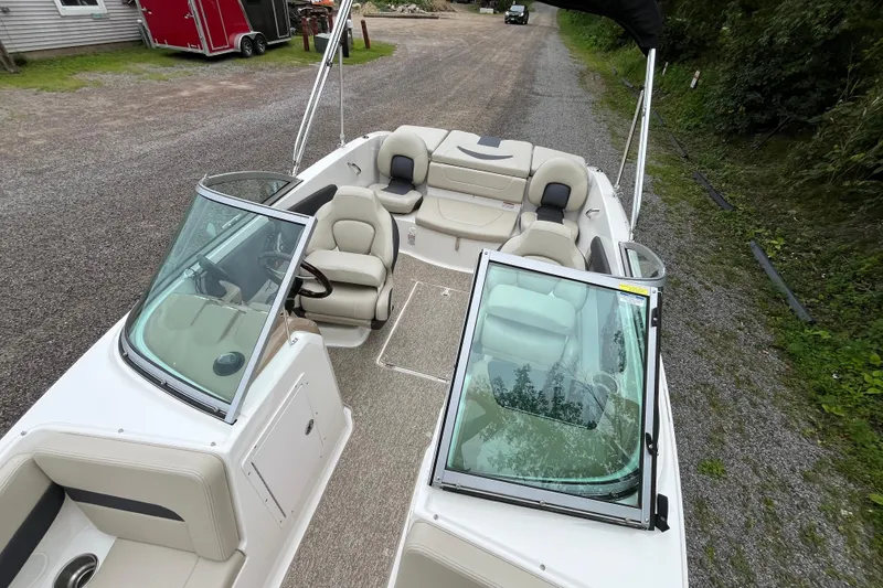 Slide: The Image of 2014 Chaparral 18 H2O Ski & Fish boat with open seating and windshield, parked on gravel. - 28