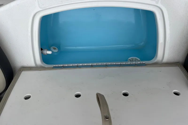 Slide: The Image of 2014 Chaparral 18 H2O Ski & Fish livewell with open lid, showcasing blue interior. - 31