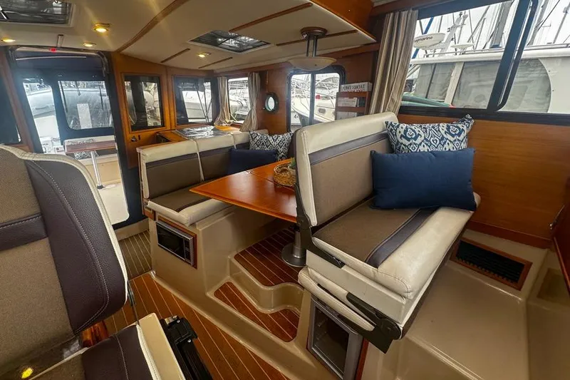 Slide: The Image of Interior of 2015 Ranger Tugs R-31 S with cozy seating and wooden accents. - 5