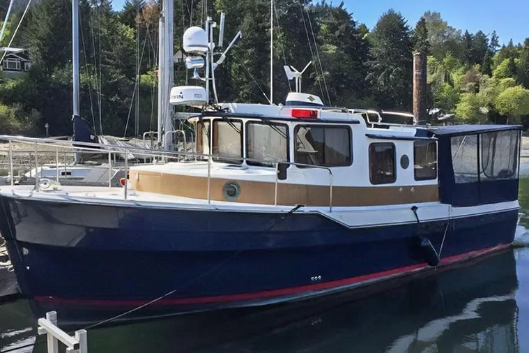 Slide: The Image of 2015 Ranger Tugs R-31 S boat docked in a serene marina setting. - 6