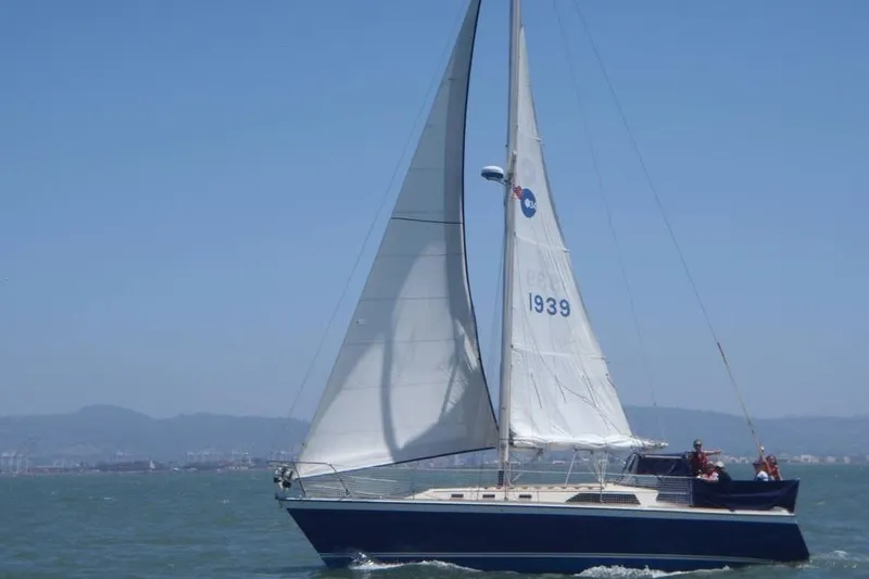The Image of 1981 O'Day 34 sailboat cruising on open water under clear blue skies. - 0