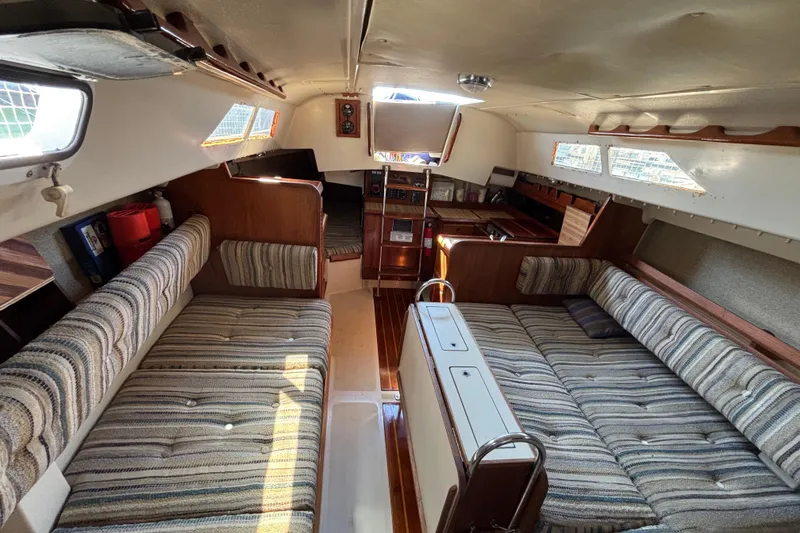 Slide: The Image of Interior of 1981 O'Day 34 sailboat with striped upholstery and wooden accents. - 11