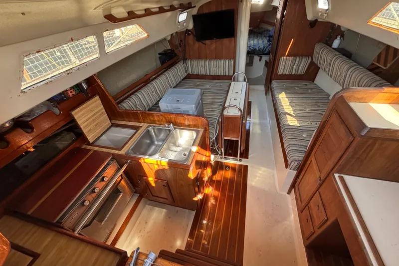 Slide: The Image of Interior of 1981 O'Day 34 sailboat with kitchen, seating, and wood finishes. - 12