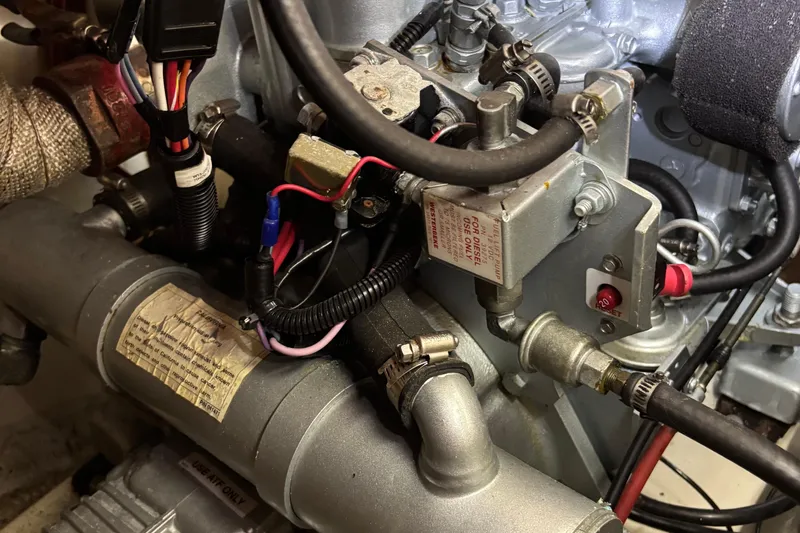 Slide: The Image of Engine components of a 1981 O'Day 34 sailboat, featuring wiring and fuel system. - 14