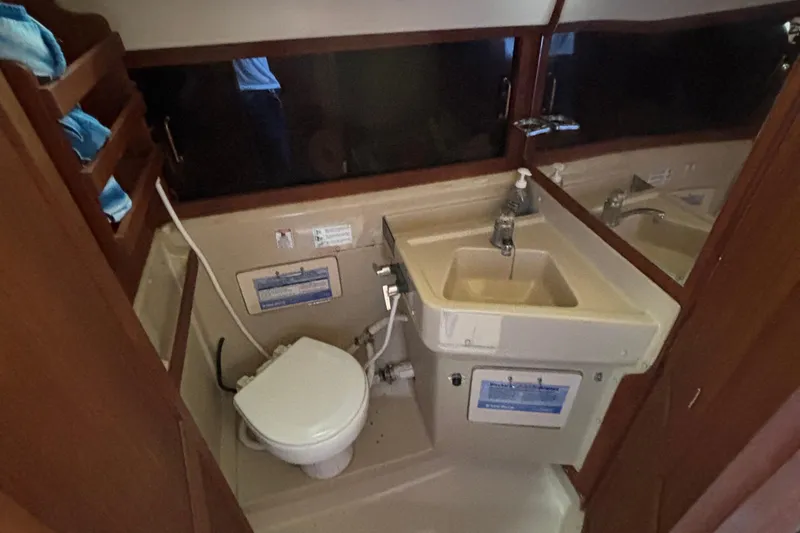 Slide: The Image of 1981 O'Day 34 yacht bathroom with sink, toilet, and wooden shelving. - 25