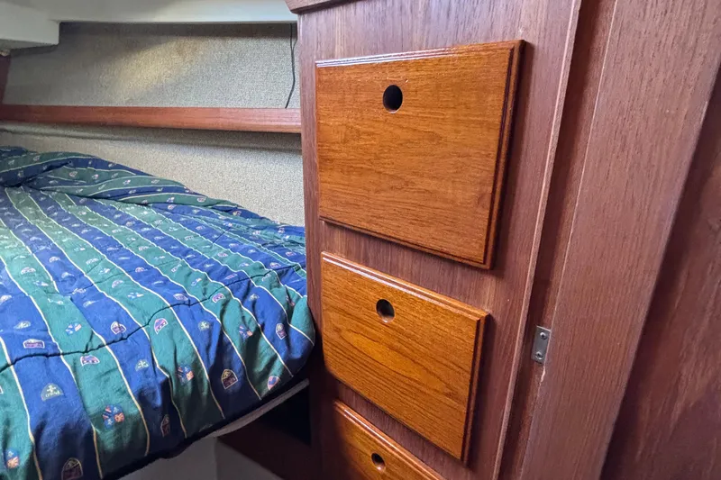 Slide: The Image of Interior of 1981 O'Day 34 sailboat with wooden drawers and patterned bedding. - 26