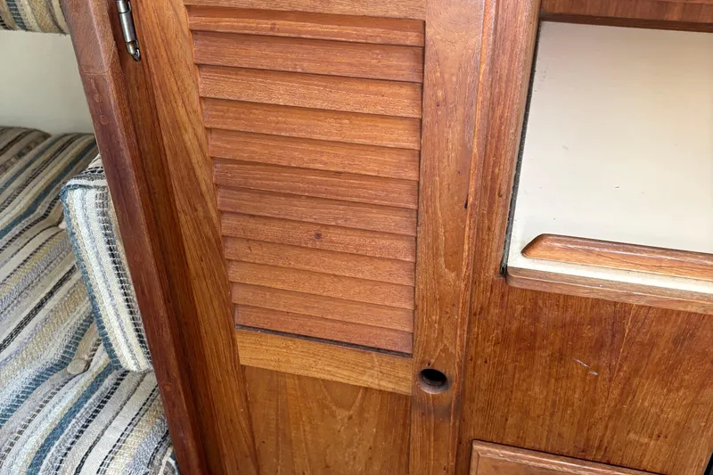 Slide: The Image of Wooden interior of 1981 O'Day 34 sailboat with striped upholstery. - 27