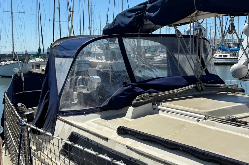 Slide: The Image of 1981 O'Day 34 sailboat with blue canvas cover docked in marina. - 8