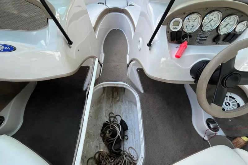 Slide: The Image of 2008 Four Winns H180 boat interior with dashboard, steering wheel, and storage compartment. - 16