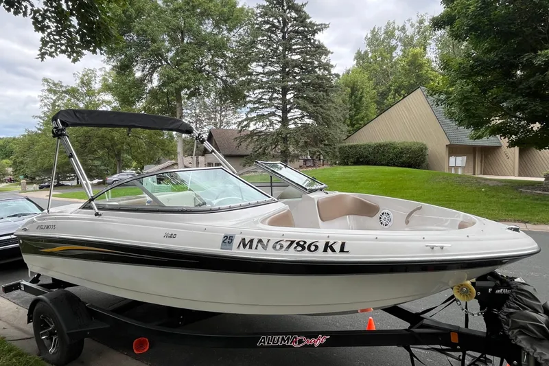 Slide: The Image of 2008 Four Winns H180 boat on trailer, parked in a suburban neighborhood. - 2