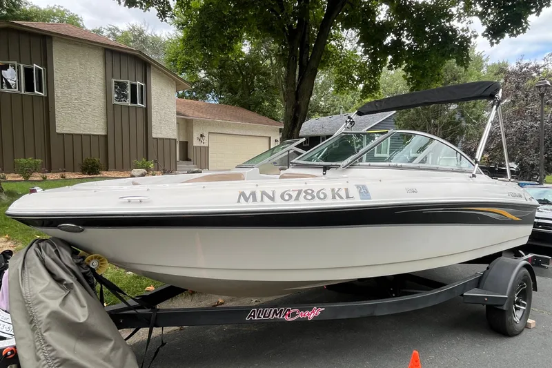 Slide: The Image of 2008 Four Winns H180 boat on trailer, parked in residential driveway. - 3