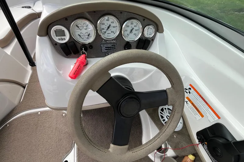 Slide: The Image of 2008 Four Winns H180 boat dashboard with steering wheel and gauges. - 8