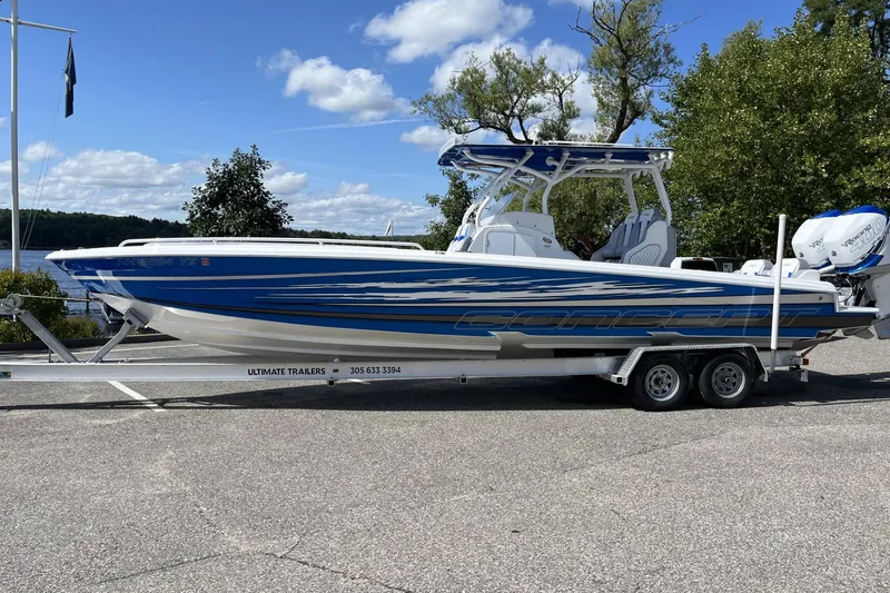 Slide: The Image of 2021 Concept 32' Open Deck boat on trailer, blue and white design, parked outdoors. - 0
