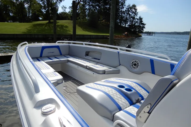 Slide: The Image of 2021 Concept 32' Open Deck boat with blue and white seating, docked by a scenic lake. - 5