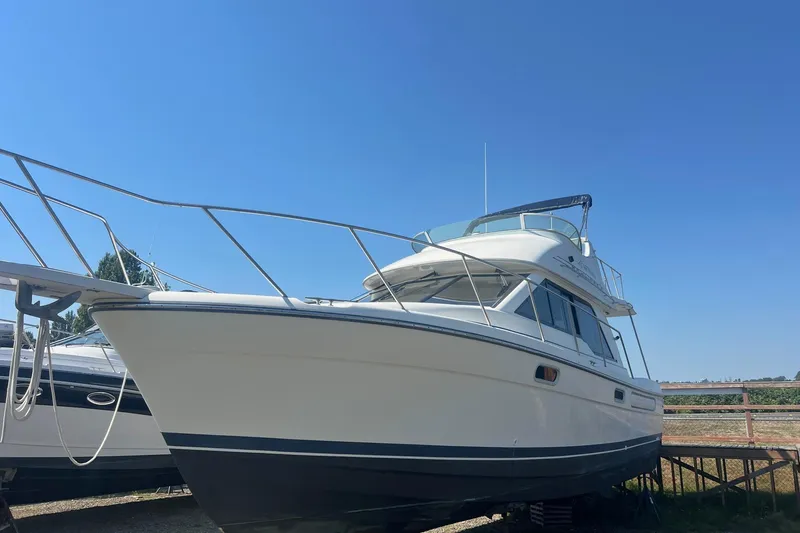 Slide: The Image of 2000 Bayliner 3388 Command Bridge Motoryacht on display under clear blue sky. - 2