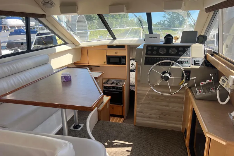 Slide: The Image of Interior of 2000 Bayliner 3388 Command Bridge Motoryacht with helm, dining area, and kitchen. - 24