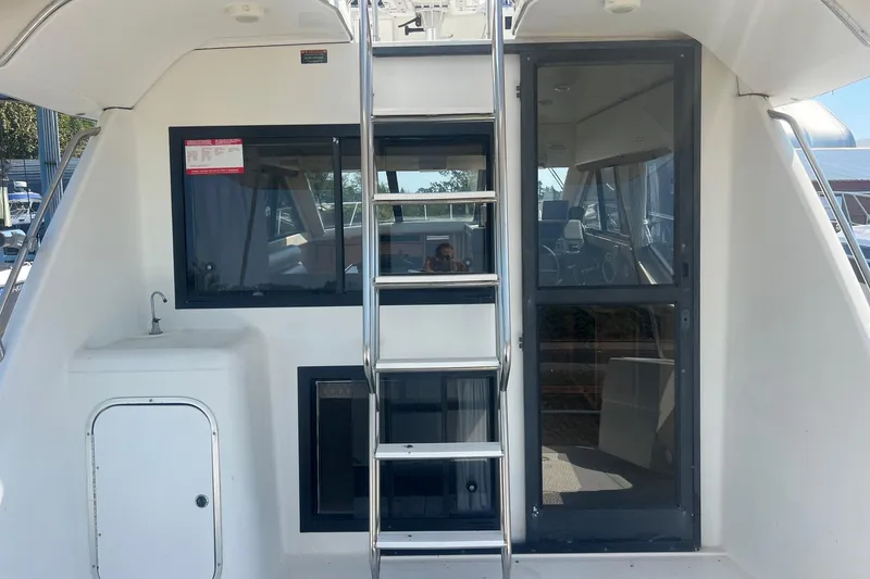 Slide: The Image of 2000 Bayliner 3388 Command Bridge Motoryacht, rear view with ladder and cabin entrance. - 7