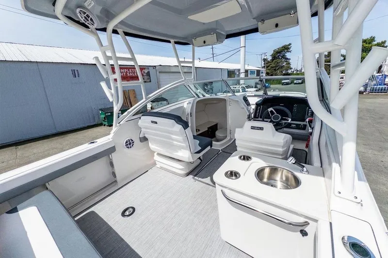 Slide: The Image of 2021 Robalo R247 Dual Console boat interior with seating, steering, and sink. - 8