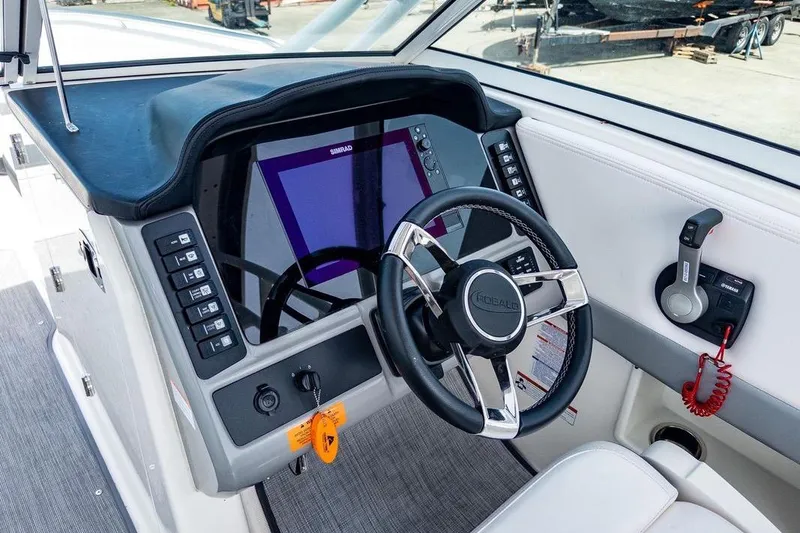 Slide: The Image of 2021 Robalo R247 Dual Console boat dashboard with steering wheel and control panel. - 9