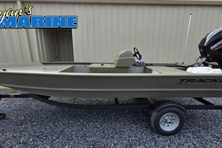 Slide: The Image of 2026 Tracker Grizzly 1648 SC boat on gravel lot, surrounded by parked vehicles. - 10