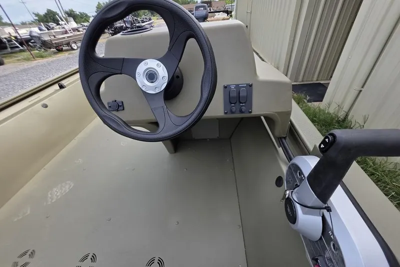 Slide: The Image of 2026 Tracker Grizzly 1648 SC boat with Mercury outboard motor on gravel lot. - 3