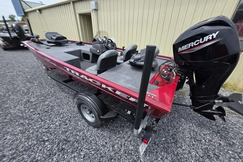 Slide: The Image of 2020 Tracker Pro 170 boat with Mercury engine, parked on gravel near a building. - 5