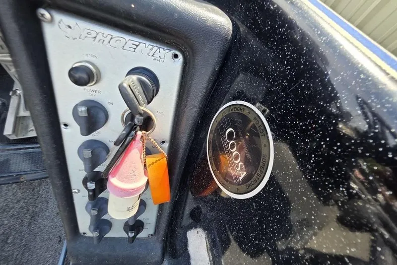 Slide: The Image of Control panel of a 2012 Phoenix 721 ProXP boat with keys and Coosa composite label. - 13
