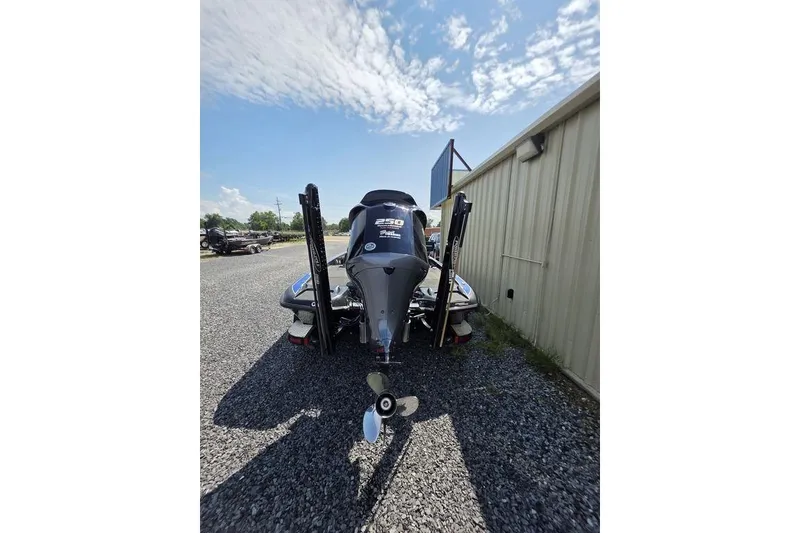 Slide: The Image of 2012 Phoenix 721 ProXP boat rear view with outboard motor, parked on gravel. - 8