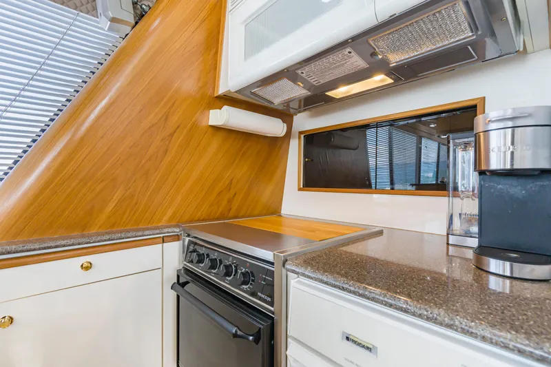 Slide: The Image of 1997 Bayliner 4788 Pilot House Motoryacht kitchen with stove, microwave, and coffee maker. - 13