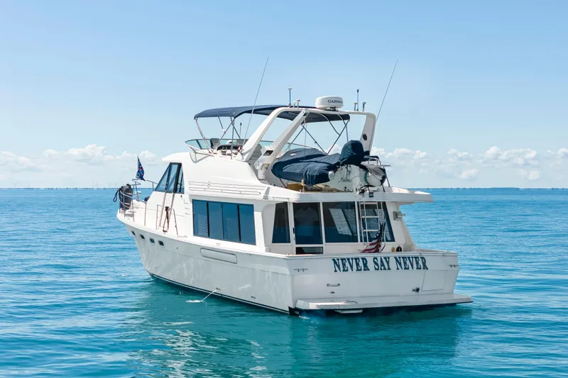 Slide: The Image of 1997 Bayliner 4788 Pilot House Motoryacht on calm blue waters, rear view. - 2