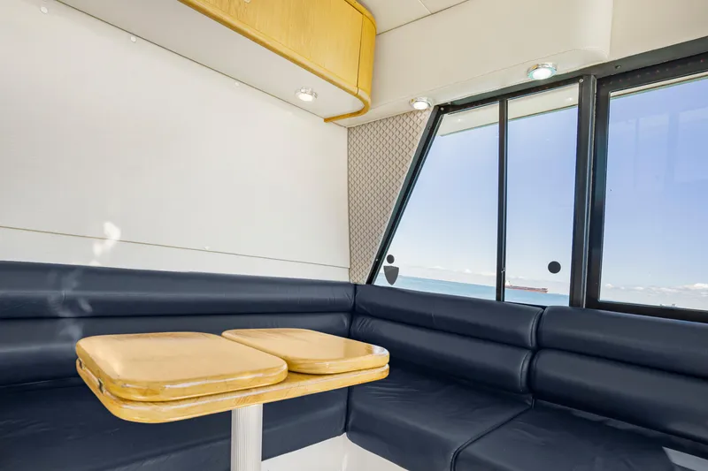 Slide: The Image of Interior of 1997 Bayliner 4788 Pilot House Motoryacht with blue seating and ocean view. - 25
