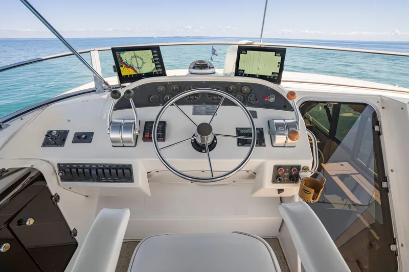 Slide: The Image of 1997 Bayliner 4788 Pilot House Motoryacht helm with navigation screens and steering wheel. - 28