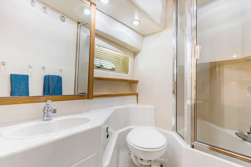 Slide: The Image of Bathroom interior of 1997 Bayliner 4788 Pilot House Motoryacht, featuring sink, toilet, and shower. - 38