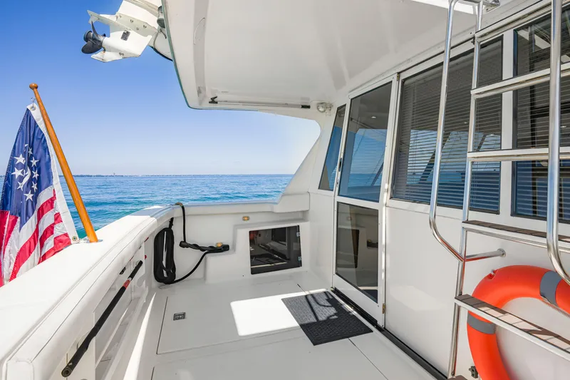 Slide: The Image of 1997 Bayliner 4788 Pilot House Motoryacht deck with ocean view and American flag. - 4