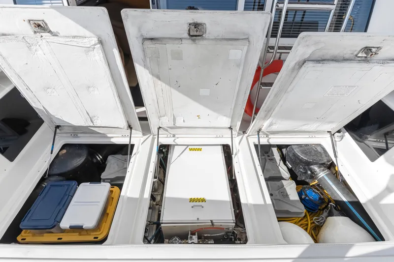 Slide: The Image of Open storage compartments on a 1997 Bayliner 4788 Pilot House Motoryacht, revealing equipment and supplies. - 6