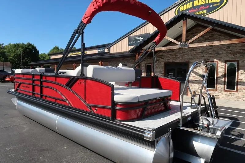 Slide: The Image of 2026 Bennington S Swingback 22 SSB SPS pontoon boat in vibrant red, parked outside dealership. - 6