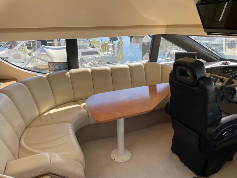 Slide: The Image of Interior of 2000 Carver 530 Voyager Pilothouse with leather seating and wooden table. - 12