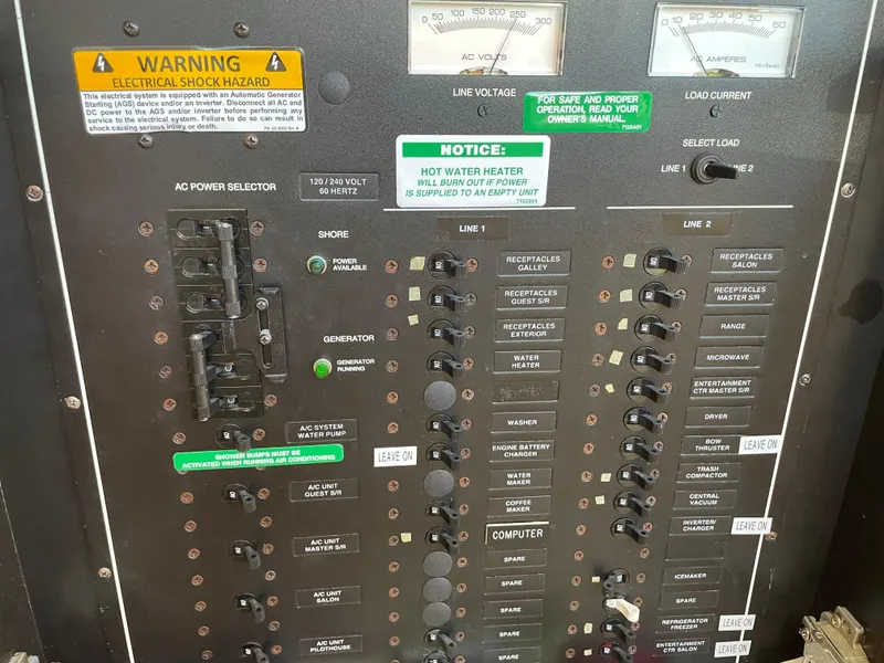 Slide: The Image of Electrical panel of a 2000 Carver 530 Voyager Pilothouse with warning labels and switches. - 42