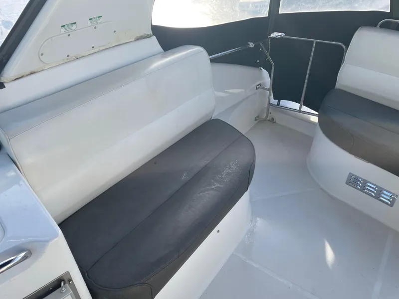 Slide: The Image of 2000 Carver 530 Voyager Pilothouse interior seating area with white and gray cushions. - 48